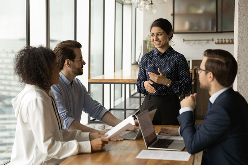 Smiling,Indian,Businesswoman,Leading,Corporate,Meeting,With,Diverse,Colleagues,,Coach