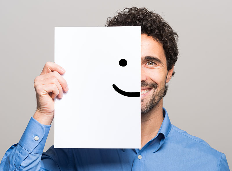 Happy,Man,Covering,Half,His,Face,With,A,Smiling,Emoticon